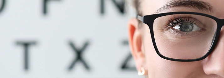 Person With Glasses In Front Of Eye Exam Chart